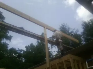 Carpenter setting a ridge beam over a new addition frame — Ice Dam Removal by Roofing Brothers in Pe Ell
