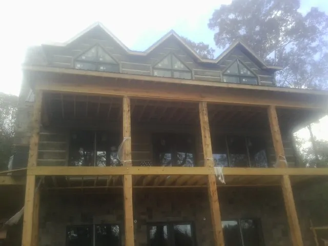 Dormers and porch framing on a large log home under construction — Roof Coating work by our crew in Pe Ell
